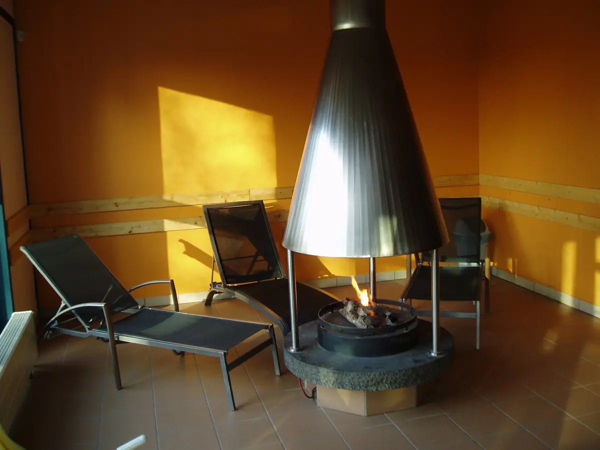 Ruheraum der Sauna mit Kamin und Liegen